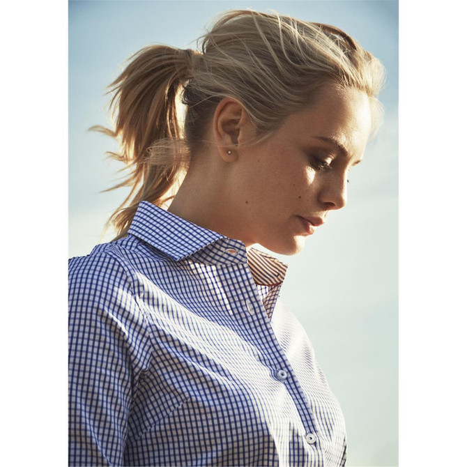A women's button-up shirt in navy blue and white check pattern, with a collar, being worn by a model outdoors.