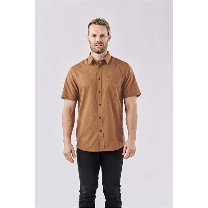 A short-sleeved, button-up shirt in a brown colour with a dotted pattern, featuring a logo on the chest.