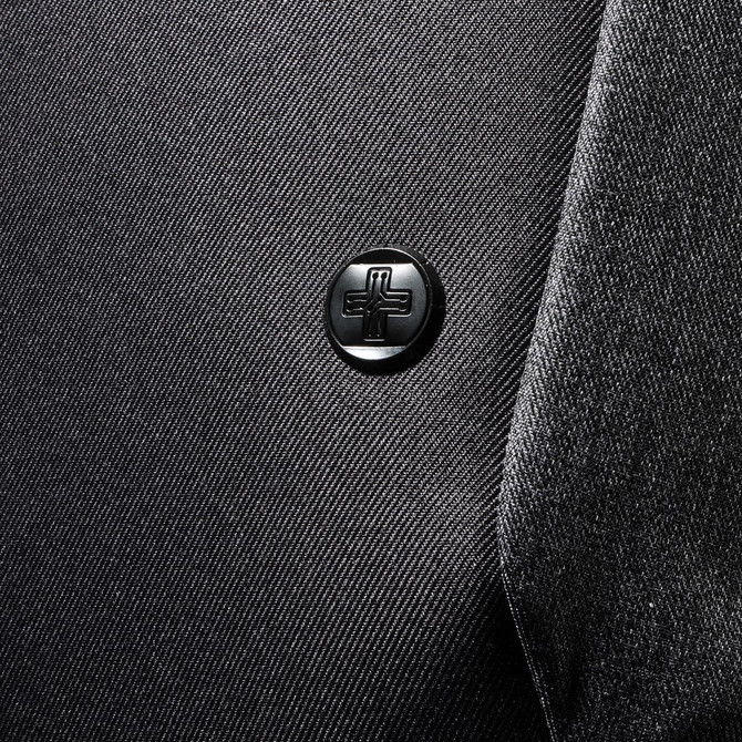 A close-up of a black fabric texture featuring a round black logo on a backpack.