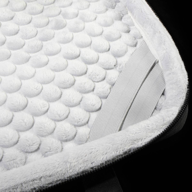 A close-up of a white padded interior of a laptop sleeve, featuring a textured surface and elastic straps.