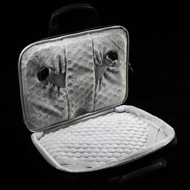 A grey laptop sleeve featuring a soft, padded interior and adjustable straps for securing a device.