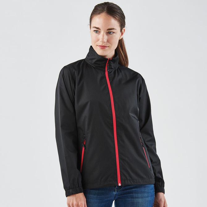 A woman wearing a black rain jacket with red zippers and accents, featuring a collar and side pockets.