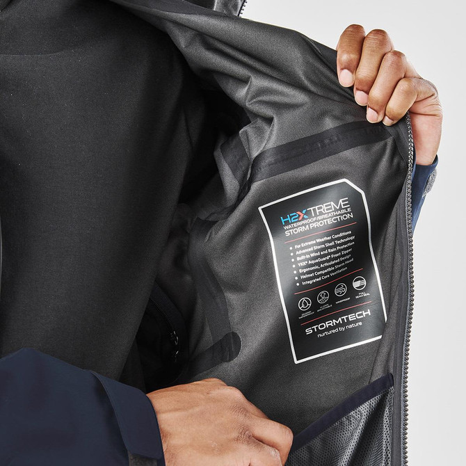A close-up of a men's jacket interior, featuring a dark lining and a branded label for storm protection.