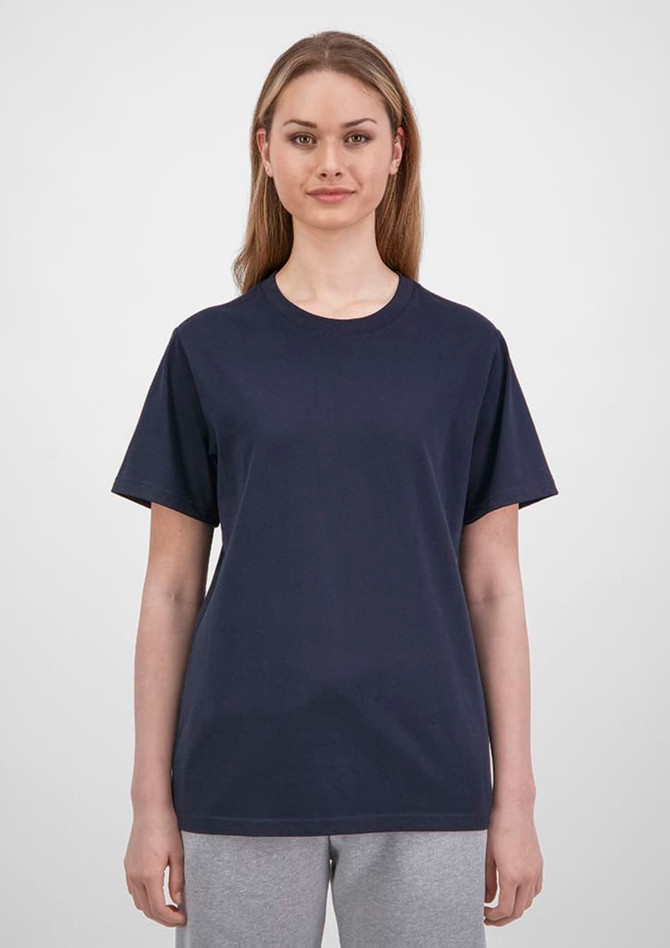 A women's short sleeve tee in navy blue with a relaxed fit, paired with light grey pants. The tee has a logo.