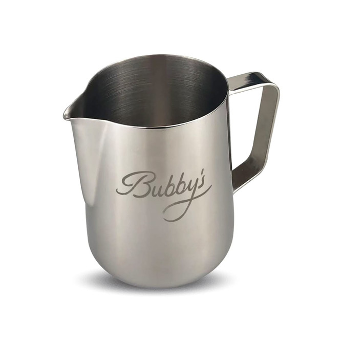 A stainless steel milk jug with a polished finish and a curved handle, featuring a logo on the side.