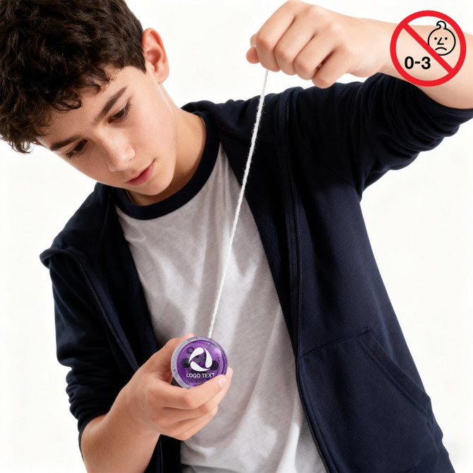 A boy is playing with a purple yoyo, pulling the string down as he focuses on his trick.