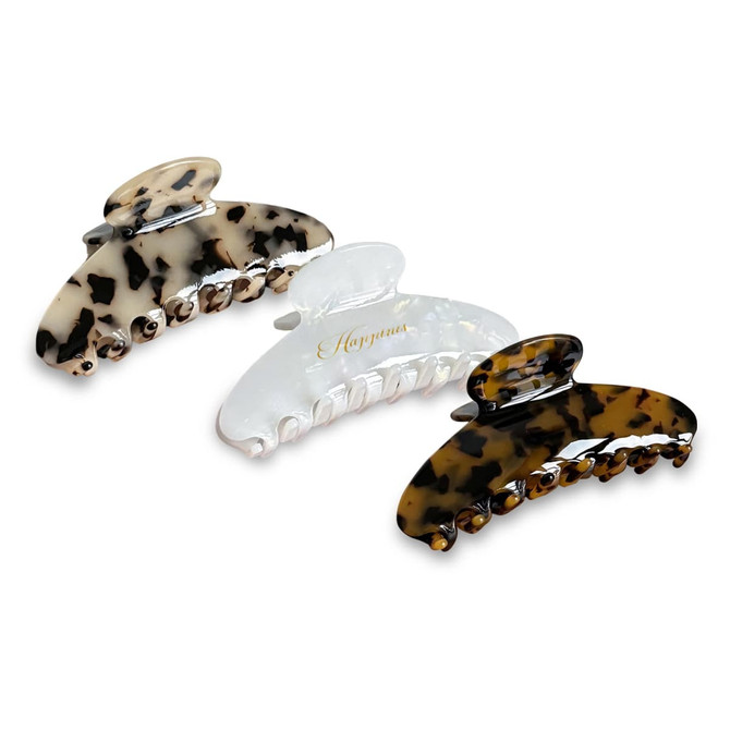 Three acetate hair clips displayed in black, clear, and tortoiseshell patterns, featuring a branding logo.