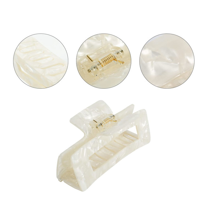 A hair claw clip in a lustrous ivory colour, featuring a spring mechanism and a textured design.