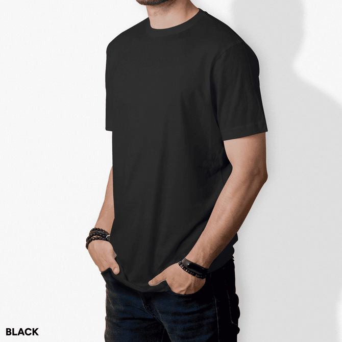 A black T-shirt with short sleeves, featuring a plain design. The model has hands in pockets and is wearing bracelets.