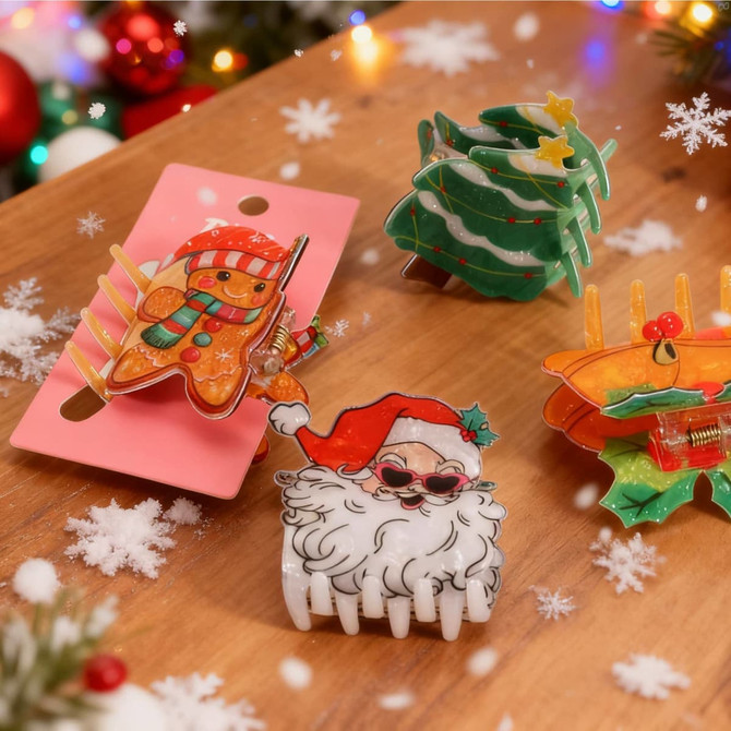Four festive hair claws featuring a Santa, gingerbread man, Christmas tree, and holly, in vibrant colours on a pink backing.