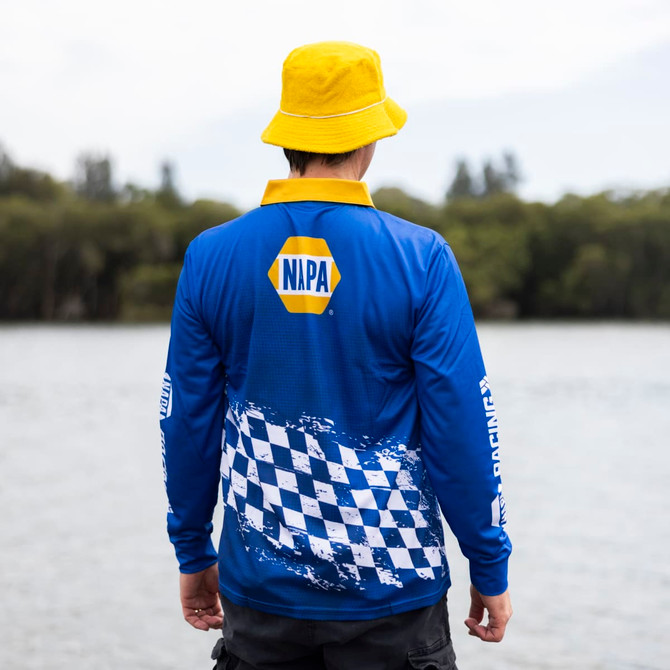 A blue long sleeve polyester fishing polo featuring a checkered pattern and a logo. A yellow bucket hat is worn.