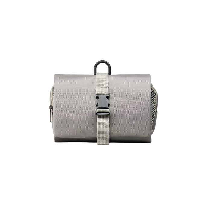 A grey folding travel toiletry bag with a strap closure and a hanging loop, featuring a textured fabric surface.