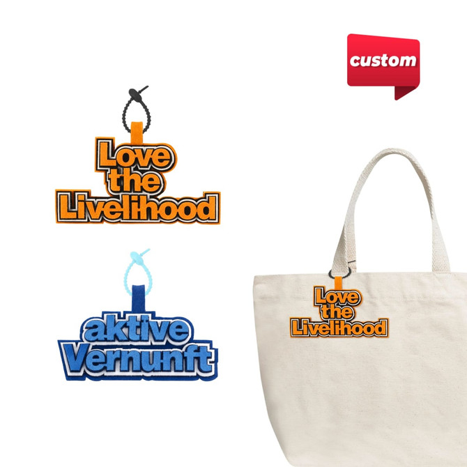 Two custom felt hanging tags in orange and blue, featuring logos, attached to a cream-coloured tote bag.