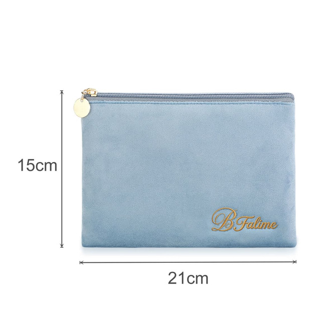 A flat makeup bag in light blue with a gold zipper and branding. Dimensions: 21cm x 15cm.