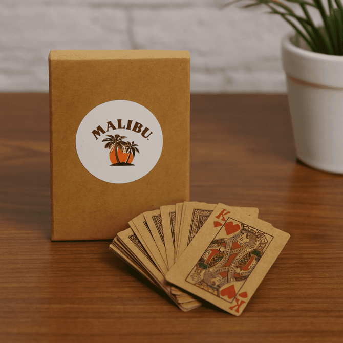 A set of eco-friendly playing cards in a brown box with a logo, featuring intricate designs in earthy tones.