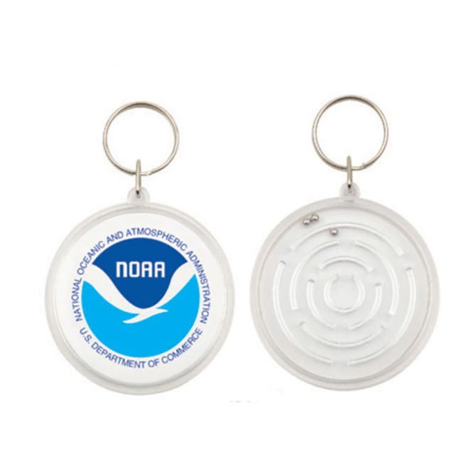 A circular keychain featuring a maze design on one side and a logo with blue and white colours on the other side.