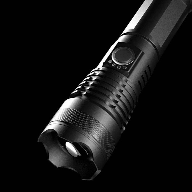 A black outdoor torch with a textured grip and a round head, featuring a circular light source and an on/off button.