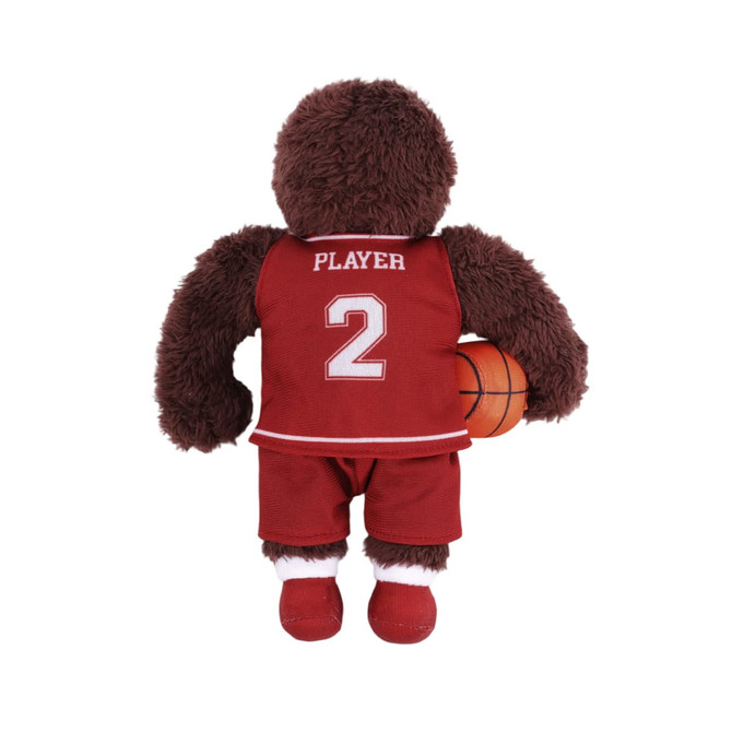 A brown plush toy dressed in a red basketball uniform, holding a miniature basketball, with a logo on the outfit.
