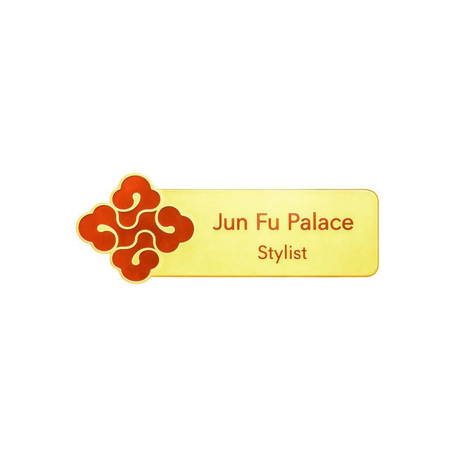 A custom metal name badge featuring a gold background with a red decorative logo and text for "Jun Fu Palace Stylist."