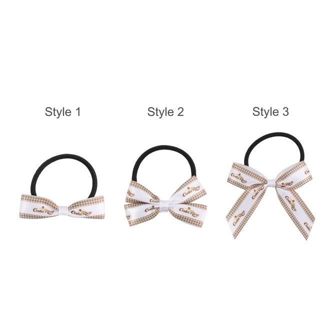 Three elastic hair bows in different styles: one black, one white with a checkered pattern, and one with a larger white bow.