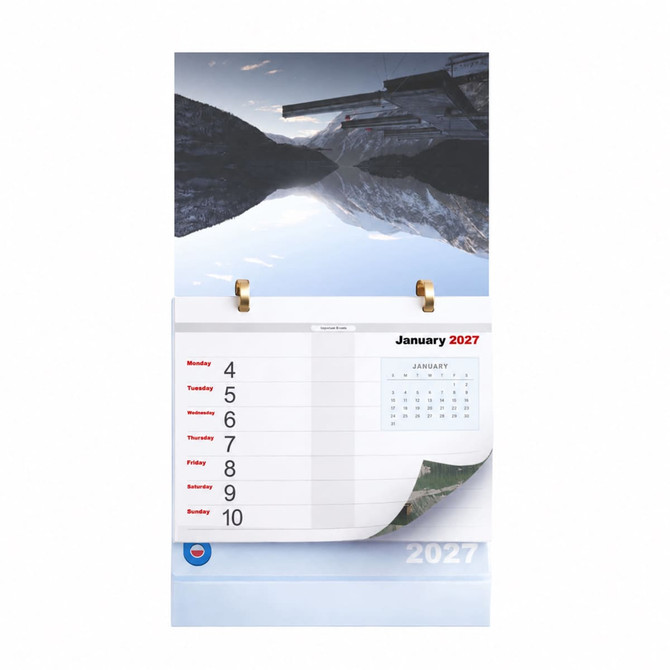 A desk calendar featuring a mountain landscape, with January 2027 pages and a gold ring binding at the top.