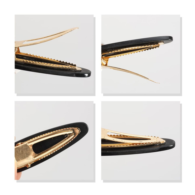 An acetate hair alligator clip in black and gold, featuring a textured grip and a sleek design.