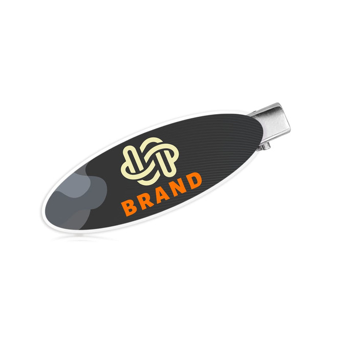 An oval acrylic hair clip in black and white features a logo and an orange accent.