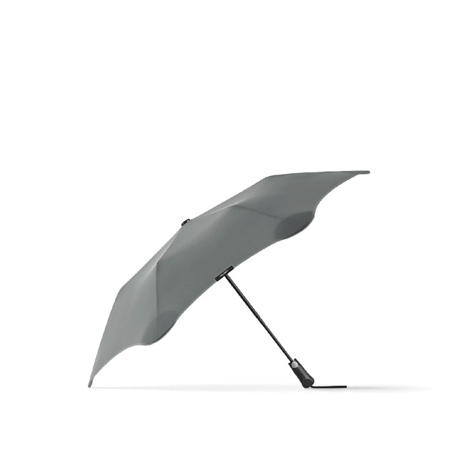 A grey BLUNT Metro Umbrella with a sleek, aerodynamic design and a branding logo on the handle.