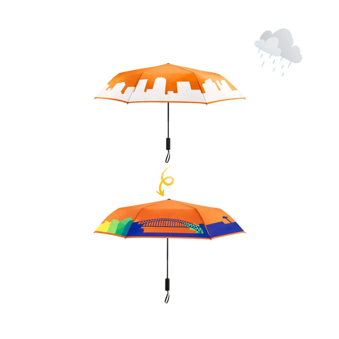 A 23'' colour-changing umbrella featuring an orange design with skyline graphics and a vibrant underside illustration.