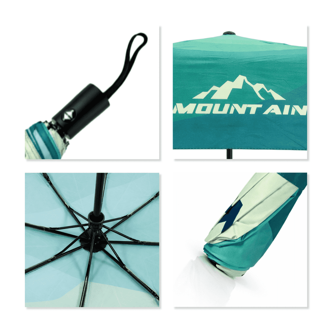 A compact folding umbrella featuring a turquoise and white design with a mountainous pattern and a handle with a logo.