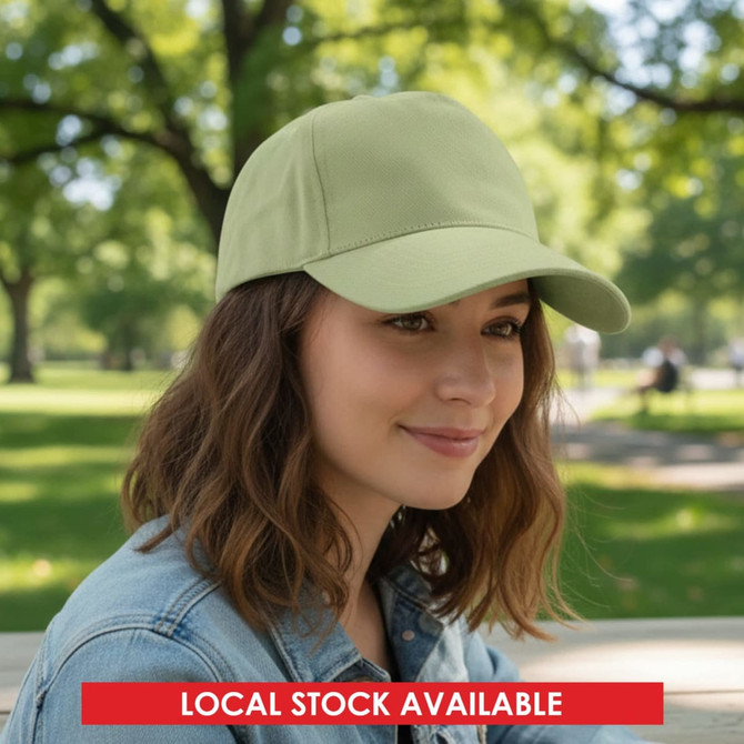 A cap in a light green shade, featuring a curved brim and a logo, worn by a woman in a park setting.