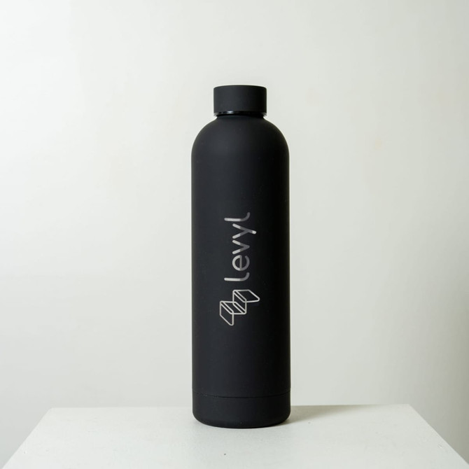 A drink bottle in matte black with a logo on the side, featuring a sleek design and a 750ml capacity.