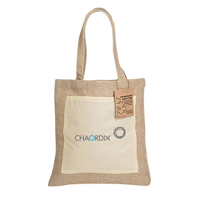 A jute tote bag in natural brown with a cream pocket and a logo on the front. Features long handles.