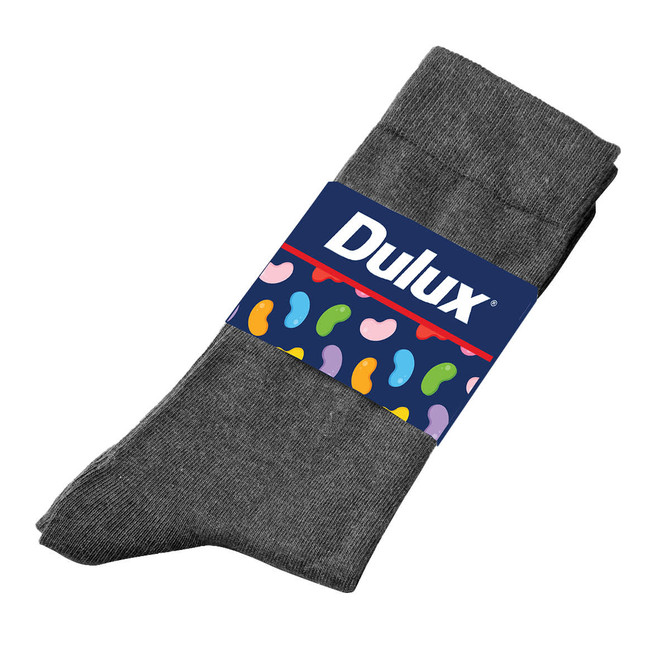A pair of grey seamless socks with a branded label featuring a colourful design on the band.