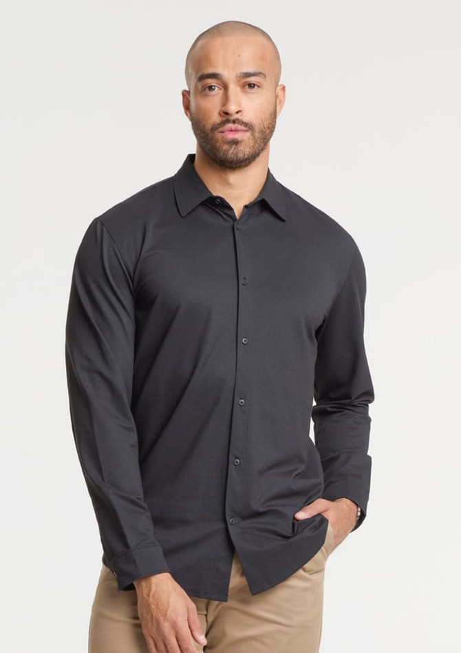 A grey long sleeve shirt with a button-up front, featuring a logo on the chest, worn by a male model.