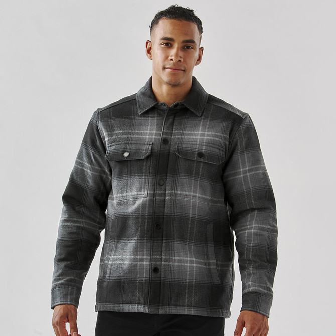 A men's black and grey plaid jacket with a Sherpa lining and two chest pockets, featuring a logo on the front.