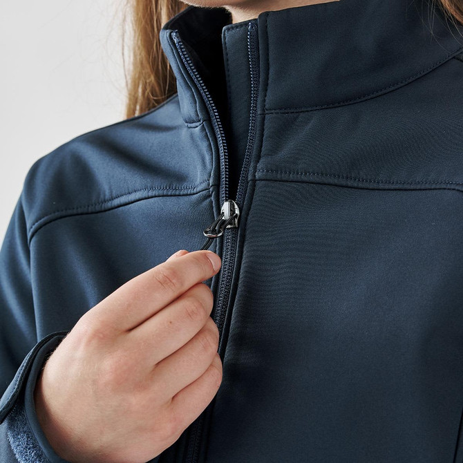 A navy women's softshell jacket with a zippered front, featuring a hand adjusting the zipper.