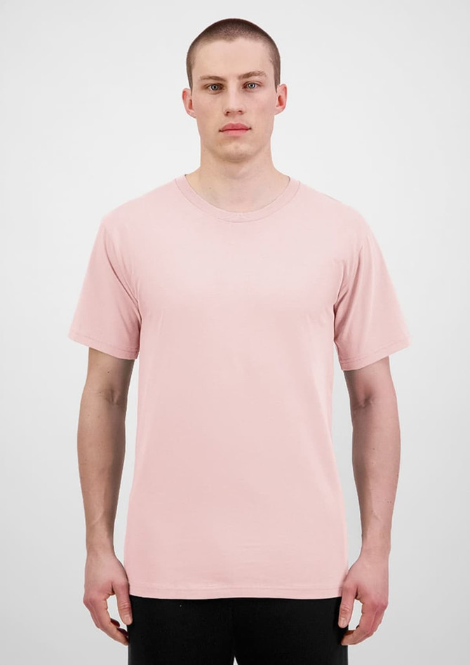 A plain pink short sleeve tee is displayed on a model against a neutral background. The shirt features a logo.