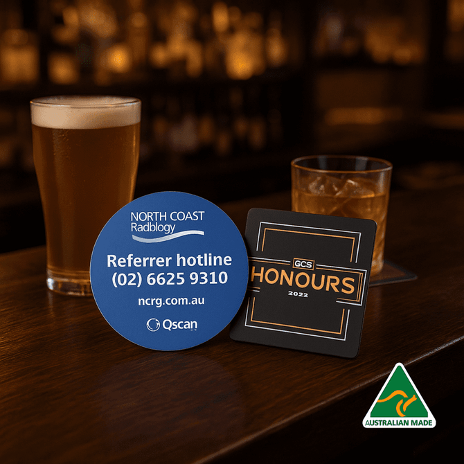 A drink bottle and two circular coasters in blue and black, featuring logos and text, on a wooden bar top.