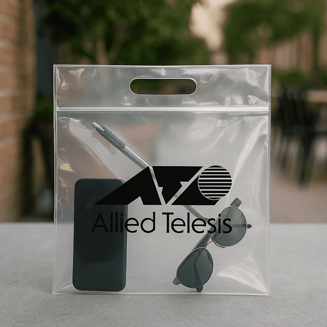 A clear tote bag containing a phone, sunglasses, and a pen, featuring a logo on the front.