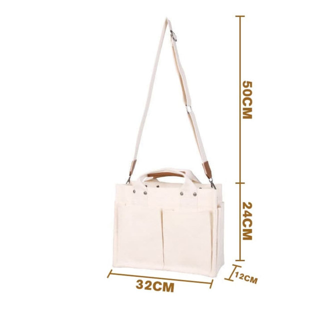 A cream canvas tote bag with adjustable straps, featuring multiple pockets and a sturdy handle for easy carrying.
