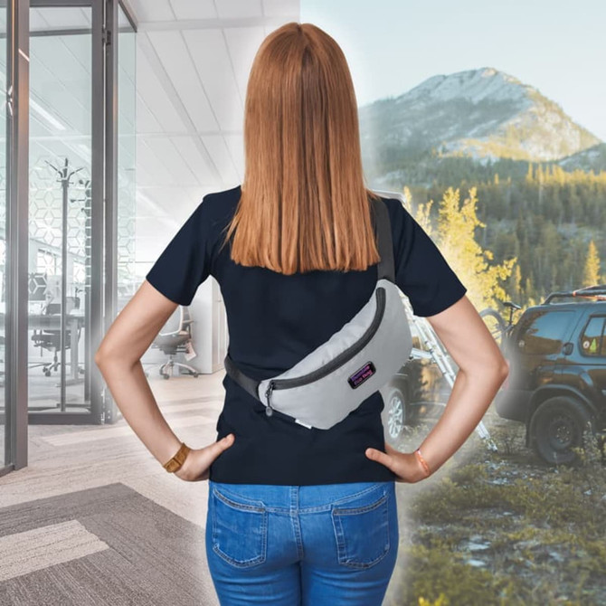 A person wearing a grey bumbag on their waist, facing away, with an office and outdoor mountain scene in the background.