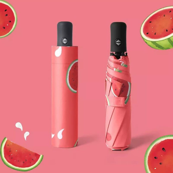 A full colour umbrella featuring a watermelon print, with a matching protective cover in a pink hue.