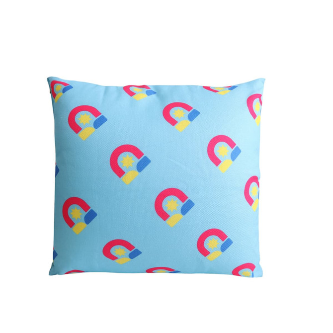 A square cushion featuring a blue background with multicoloured magnet prints and a logo.