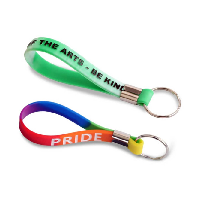Two silicone key rings in vibrant colours, one featuring a green and white design and the other in a rainbow gradient.