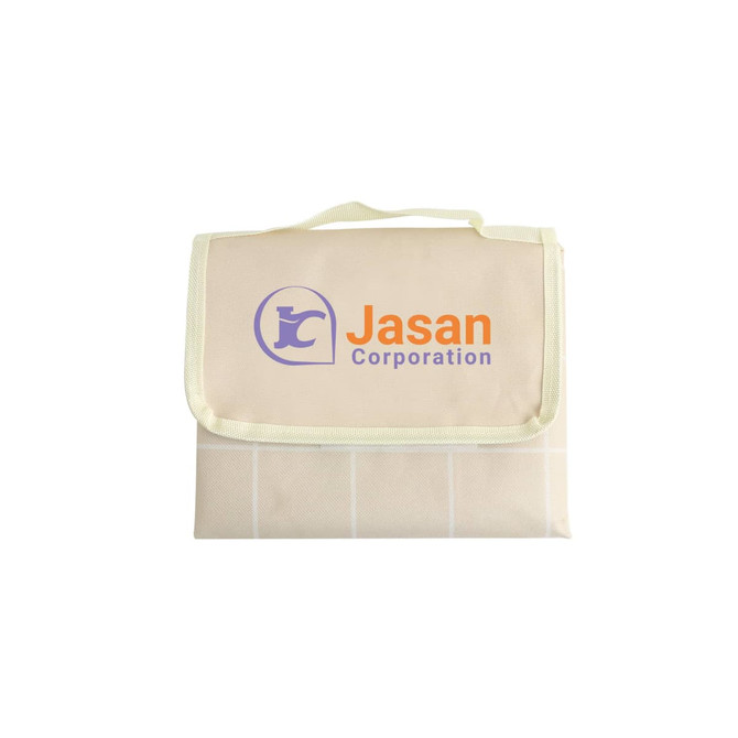 A medium picnic blanket in cream with a grid pattern and a logo on the front, featuring a carry handle.