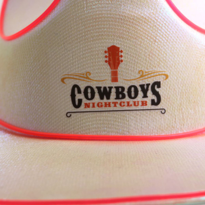 A light-coloured cowboy hat with red accents and a logo featuring a guitar and text.