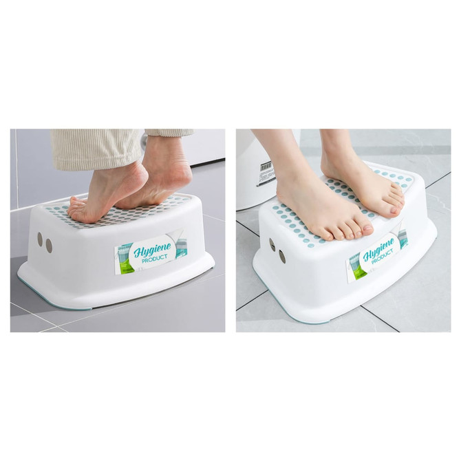 A white step stool with textured surface and a logo, being used with bare feet on a tiled floor.