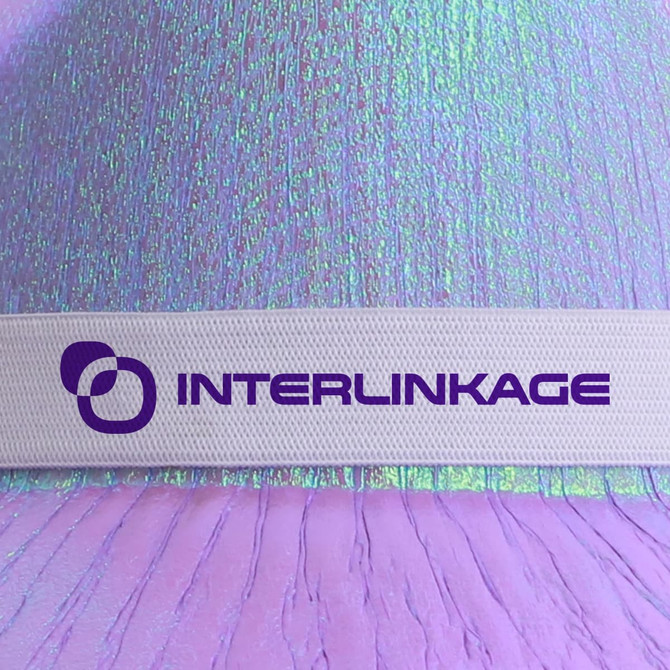 Iridescent cowboy hat in shades of purple and pink, featuring a white band with a logo.