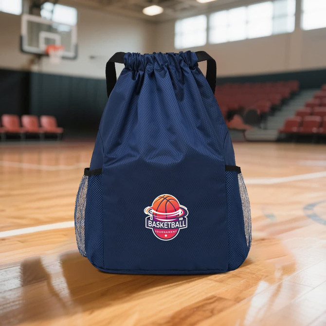 A navy drawstring backpack with mesh side pockets and a basketball logo. Set in a gymnasium with hardwood flooring.